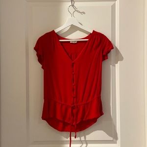 A red flow y blouse that is non-see through with beautiful button detailing